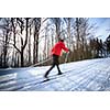 Cross-country skiing: young man cross-country skiing on a lovely sunny winter day (motion blur technique is used to convey movement)