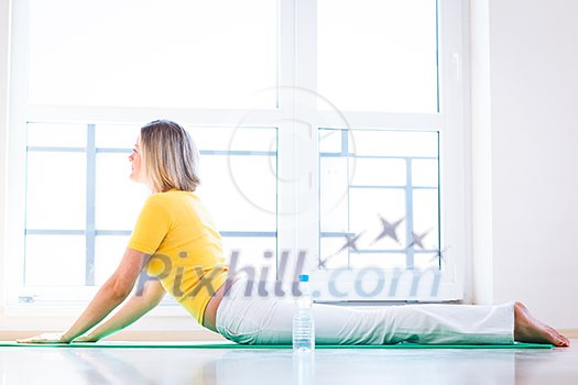 Pretty young woman doing YOGA exercise at home