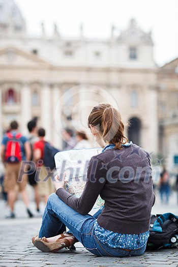 Pretty young female tourist studying a map at St. Peter's square in the Vatican City in Rome Pretty young female tourist studying a map at St. Peter's square in the Vatican City in Rome