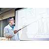 Senior chemistry professor giving a lecture in front of classroom full of students (shallow DOF; color toned image)