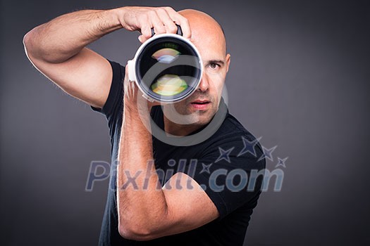 Young, pro male photographer in his studio during a photo shoot (color toned image; shallow DOF)