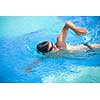 Young man swimming the front crawl in a pool