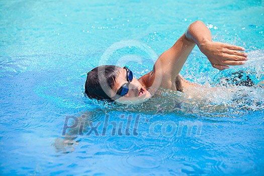 Young man swimming the front crawl/freestyle in a pool