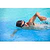 Young man swimming the front crawl/freestyle in a pool