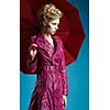 Young woman with umbrella on blue