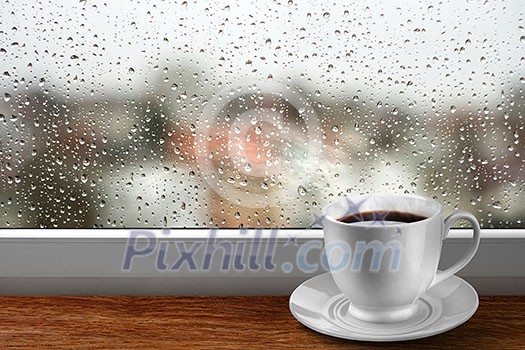 Coffee cup against window with rainy day view