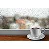 Coffee cup against window with rainy day view