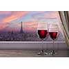 View of Paris and Eiffel tower on sunset from window with two glasses of wine