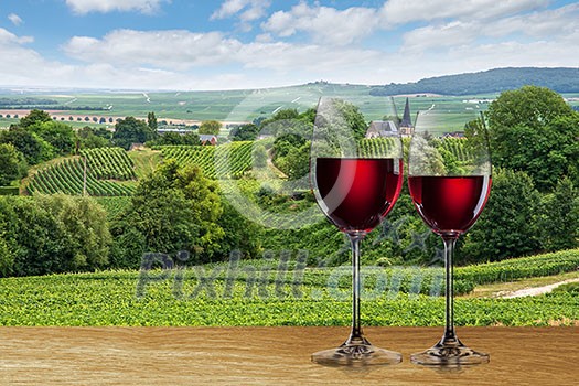 Glass of red wine against vineyard landscape