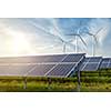 solar panels and wind generators under blue sky on sunset