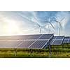 solar panels and wind generators under blue sky on sunset