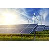 solar panels and wind generators under blue sky on sunset