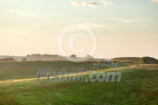 Summer landscape on sunset - field and hills