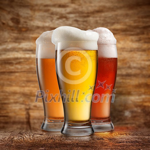 Different beer in glasses on wooden background