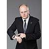 Businessman look his watch, isolated on a grey background