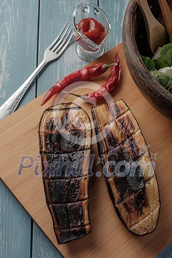Halves roasted eggplant on wooden table