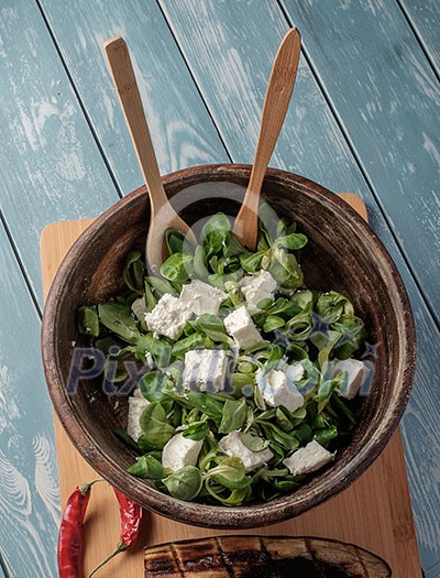 Salad of fresh greens in a wooden bowl Salad of fresh greens in a wooden bowl