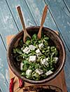 Salad of fresh greens in a wooden bowl