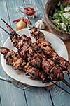 Shashlik with salad on the wooden table