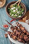 Shashlik with salad on the wooden table