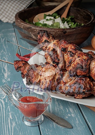 Shashlik with salad on the wooden table Shashlik with salad on the wooden table