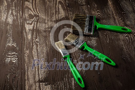 Three brushes for painting on a dark wooden table