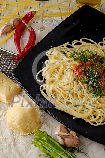 Italian pasta cooked in a rustic style with a sauce of fresh tomatoes and garlic on a wooden table. Top view Italian pasta cooked in a rustic style with a sauce of fresh tomatoes and garlic on a wooden table. Top view