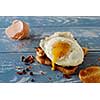 Breakfast - sandwich with fried egg and bacon over blue wooden table