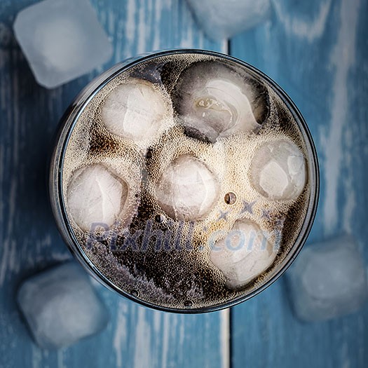 Cola in glass with ice over blue wooden table. Top view. Cola in glass with ice over blue wooden table. Top view.