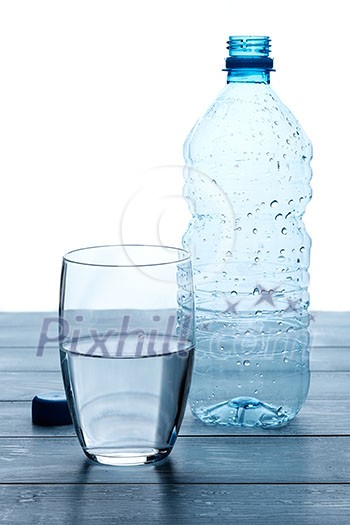 Empty bottles and glass of water on a wooden table