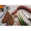Rustic breakfast. Sausage, green onion and bread on a wooden table.