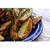 Oven-baked potatoes on blue plate. Macro. Close-up.