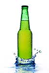 Green beer bottle with water drops and splash isolated on white