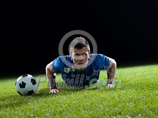 soccer player doing kick with ball on football stadium field isolated on black background soccer player doing kick with ball on football stadium field isolated on black background