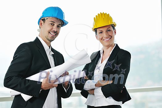 young arhitect group in big bright modern new apartment looking blueprints and building plans young arhitect group in big bright modern new apartment looking blueprints and building plans