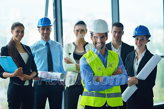 business people group on meeting and presentation  in bright modern office with construction engineer architect and worker looking building model and blueprint planbleprint plans