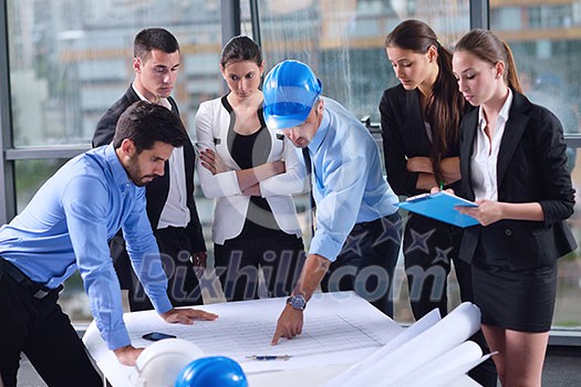 business people group on meeting and presentation  in bright modern office with construction engineer architect and worker looking building model and blueprint planbleprint plans