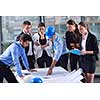 business people group on meeting and presentation  in bright modern office with construction engineer architect and worker looking building model and blueprint planbleprint plans