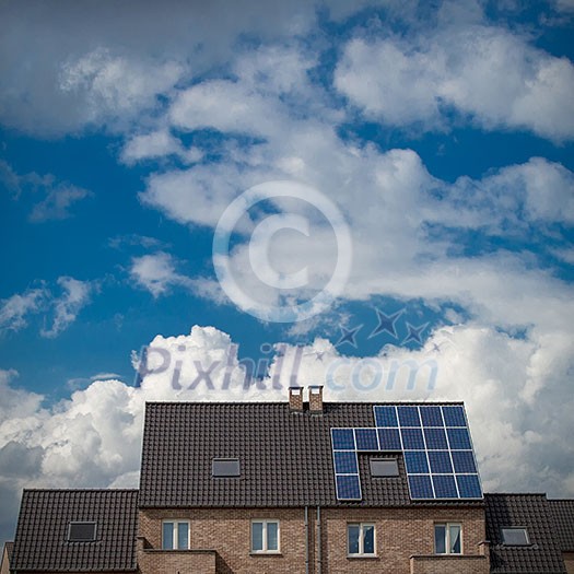 New houses with solar panels on roof under blue sky and clouds New houses with solar panels on roof under blue sky and clouds