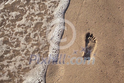 sand with footprint and water wave
