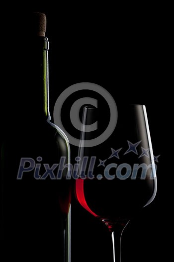 red wine in glass and bottle isolated on black