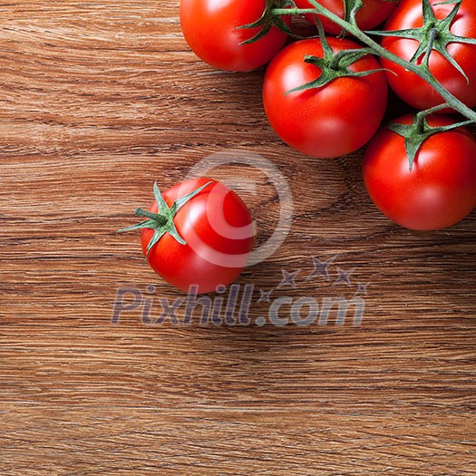 red tomatoes with green salad on wooden background