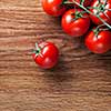 red tomatoes with green salad on wooden background