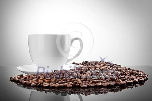 white cup with coffee beans on white 