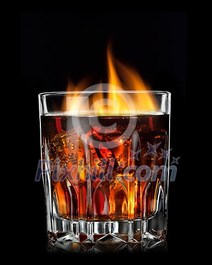 cola with cognac and fire in glass on black cola with cognac and fire in glass on black