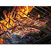 A top sirloin steak flame broiled on a barbecue, shallow depth of field