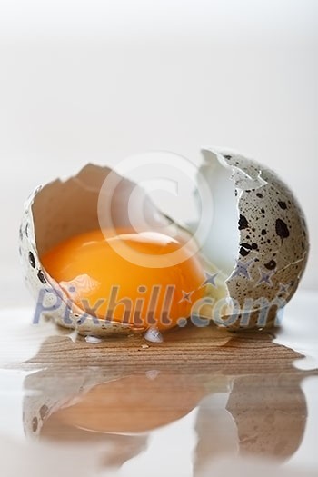 Quail egg broken on the table.