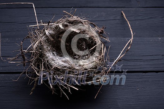 Empty straw nest with twigs on a wooden background