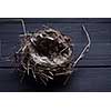 Empty straw nest with twigs on a wooden background
