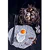 Quail eggs in the nest and a fried egg on a wooden board